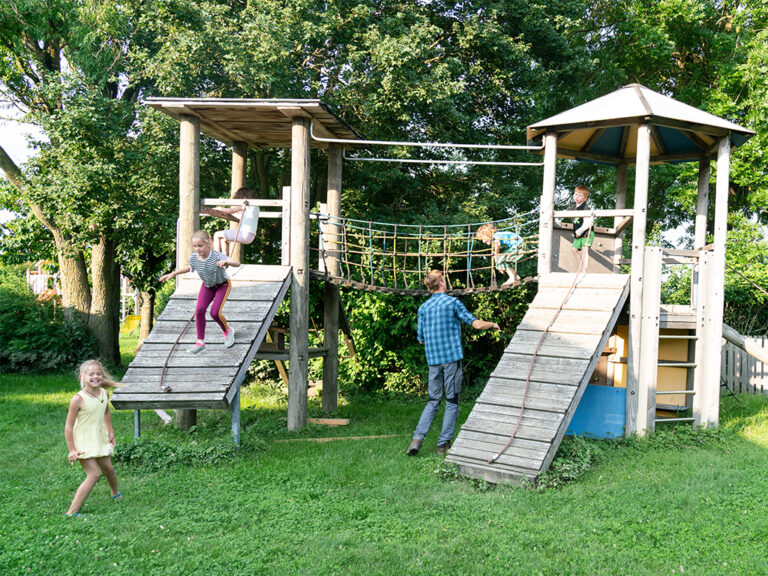 kinder spielen am klettergerüst im garten des ferienbauernhof ohr